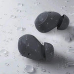 Cuffie Bluetooth AUKEY grigio: verdadero wireless-style auricolari sportivi con cuscinetti morbidi, coperti di gocce d’acqua su sfondo chiaro.